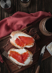 Quick breakfast, bread with salmon. Fish sandwich. Shot on a wooden table in vintage style.