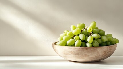 A vibrant wooden bowl filled with fresh green grapes, beautifully illuminated by natural light, enhancing their texture and inviting presentation for healthy living.
