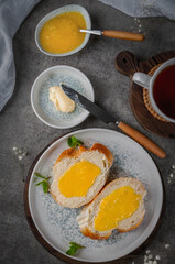 Quick breakfast, bread with butter and lemon cream. Shot on a concrete table in vintage style.