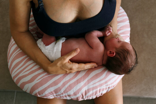 Woman with baby daughter sleeping on pillow