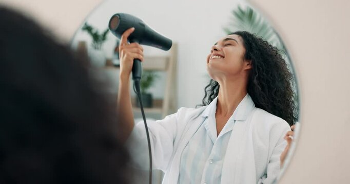 Haircare, mirror and woman with dryer, grooming and smile for routine in bathroom, morning and hairstylist. Happy, clean and reflection of person with equipment, bathrobe and drying of hair in house