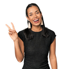 Young Filipina in black evening dress joyful and carefree showing a peace symbol with fingers.