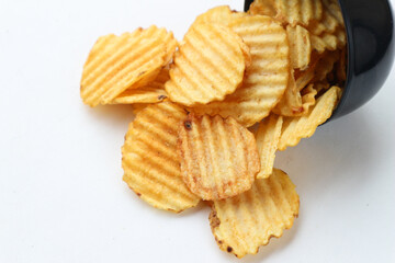 Crispy Golden Potato Chips Spilling from a Black Bowl