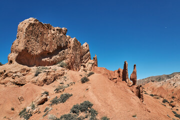 Fototapeta premium Fairy Tale Canyon on the southern shore of Issyk-Kul lake, Kyrgyzstan. Picturesque travel destination, landmark Kirgiziya. Summer skazka canyon with colorful rocks and hills. Natural park landscape