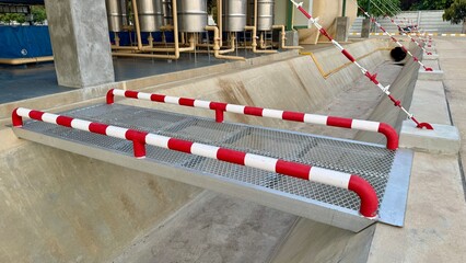 Industrial Loading Ramp with Safety Rails A close-up of a sturdy industrial loading ramp with red...