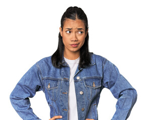 Young Filipina woman confused, feels doubtful and unsure.