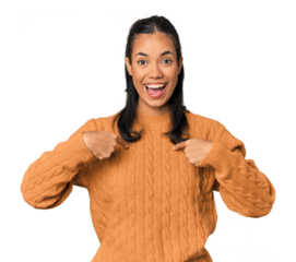 Young Filipina woman surprised pointing with finger, smiling broadly.