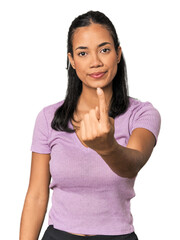 Fototapeta premium Young Filipina woman pointing with finger at you as if inviting come closer.