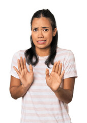 Young Filipina woman rejecting someone showing a gesture of disgust.