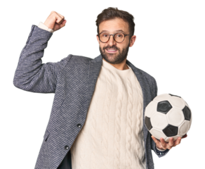Hispanic male soccer coach in studio raising fist after a victory, winner concept.