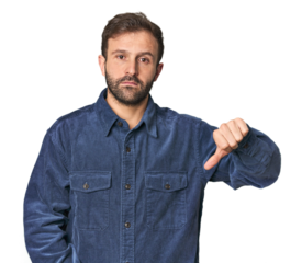 Studio portrait of young Hispanic male showing a dislike gesture, thumbs down. Disagreement concept.