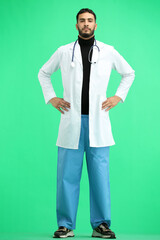 Doctor, full-length, on a green background, hands on hips