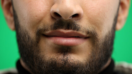 Obraz premium Man's mouth, close-up, on a green background