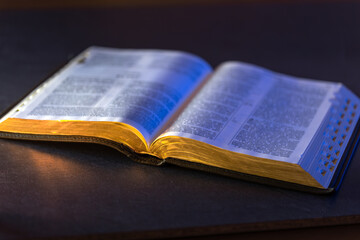 Open Holy Bible on the table. Religion concept. Bible on black background.