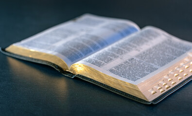Open Holy Bible on the table. Religion concept. Bible on black background.