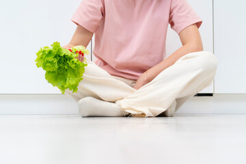 Young frustrated woman holds salad and tries to eat healthy food. Healthy lifestyle concept