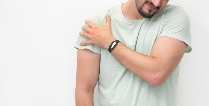 Young man suffering from shoulder pain isolated on white background