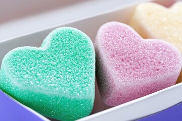 Obraz premium Colorful heart-shaped sugar candies in a box - sweet treats and romance