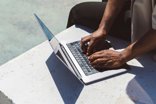 Freelancer using laptop on sunny day in park