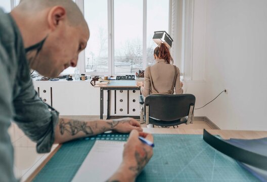 Businessman and businesswoman working in leather workshop