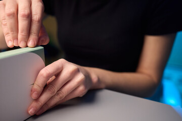 A gentle and caring hand is cradling a beautiful, vibrant plant placed on a charming wooden surface