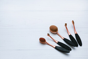 Set of unusual professional brushes on white wooden background. Make up, beauty and cosmetics concept, copy space for your text.