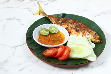 Grilled Fish with Sambal, Lime, and Vegetables on a Banana Leaf