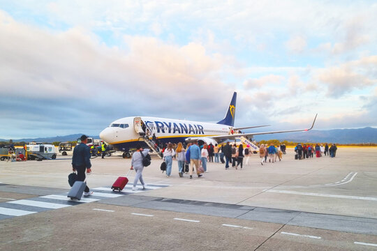 Girona, Spain, October 5, 2024: Travelers Boarding Ryanair Plane at Airport Runway during Sunset