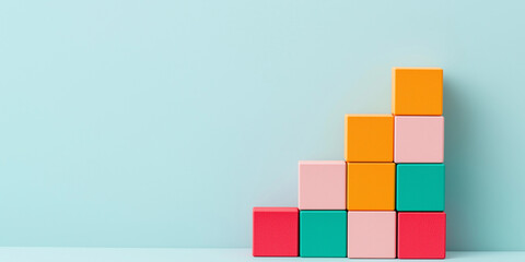 Colorful building blocks arranged in staircase pattern against light blue background, symbolizing growth and creativity