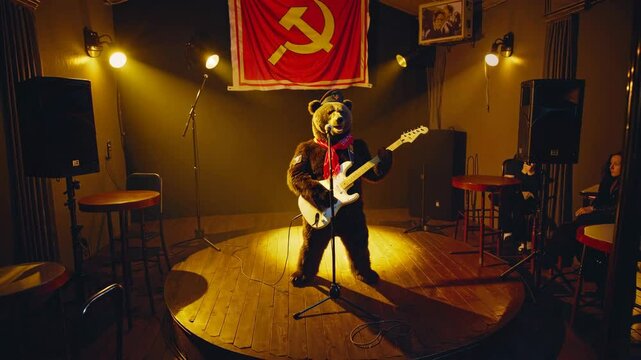 Brown bear wearing a ushanka hat and red scarf playing electric guitar and singing on stage in a nightclub with communist flag and spotlights, entertaining audience