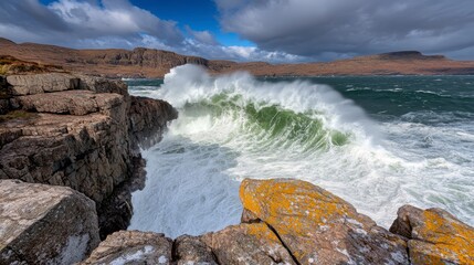 Powerful waves crashing against rocky coastline, dramatic sky with clouds. Whitish gray waves, dark gray rocks, yellow orange lichen on rocks, blue