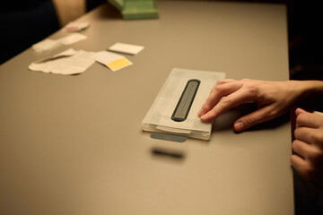 Hands Placing an Object on a Table in a Softly Dimly Lit Setting That Evokes Calmness and Serenity