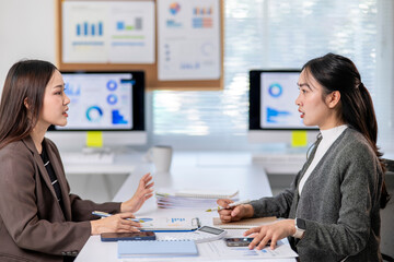 Two women are talking in a business setting