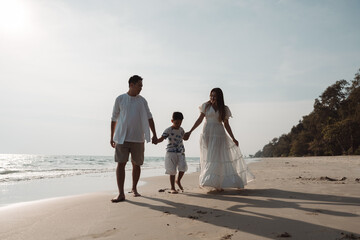 Happy asian family enjoy together on the beach in holiday vacation. family holding hands enjoying the sunset on the sea beach. Happy family travel, trip  family holidays weekend.