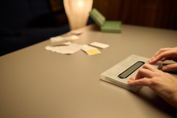 Hands Placing an Object on a Table in a Softly Dimly Lit Setting That Evokes Calmness and Serenity