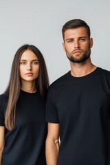 Obraz premium A man and a woman are standing next to each other in black t-shirts. The man has a beard and the woman has long hair. Concept of unity and togetherness between the two individuals