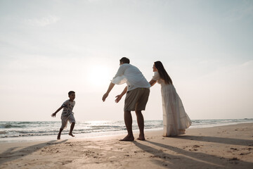 Happy asian family enjoy together on the beach in holiday vacation. Silhouette of the family holding hands enjoying the sunset on the sea beach. Happy family travel, trip  family holidays weekend.