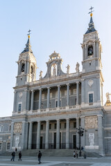 Obraz premium Almudena Cathedral main entrance in Madrid, featuring towering columns and statues that adorn the facade. The neoclassical architecture with intricate sculptures. Madrid, Spain - November 30, 2021
