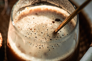 cappuccino mocha coffee with foam in a glass macro under sunny morning light, morning coffee,...