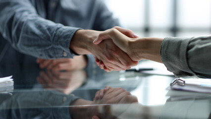 Obraz premium Document discussion and handshake at the desk in close-up in the office