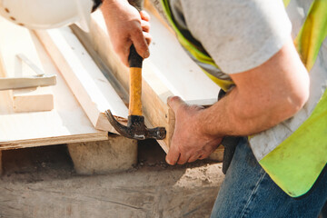 Craftsmanship in action during a construction project with detailed focus on hands using a hammer...