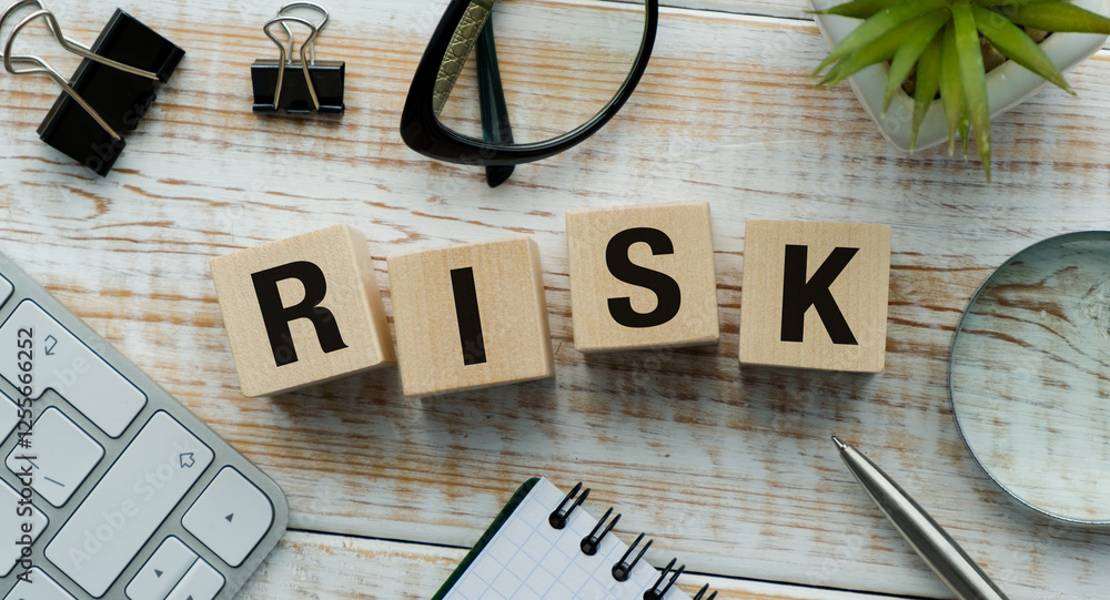 Aufkleber a wooden block with the word risk written on it is on a desk with a keyboard
