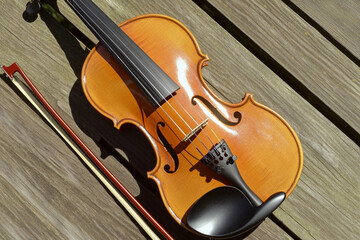Fototapeta premium Beautiful violin and bow resting on wood