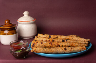 Healthy Indian Mooli or Radish paratha or stuffed flatbread with coriander and green chilli chutney on wooden background