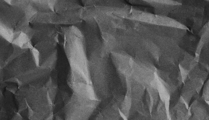 Textured black crumpled paper creates an abstract background