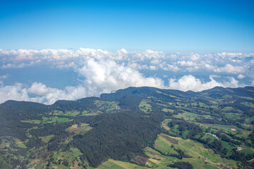 Fototapeta premium Aerial View of Lush Colombian Landscapes Under a Blue Sky with Fluffy Clouds