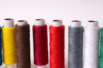 Colorful sewing thread set and needles isolated on background.
