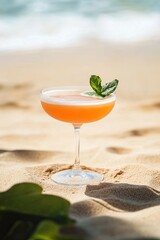 Obraz premium Refreshing cocktail garnished with mint, resting on sunlit sandy
