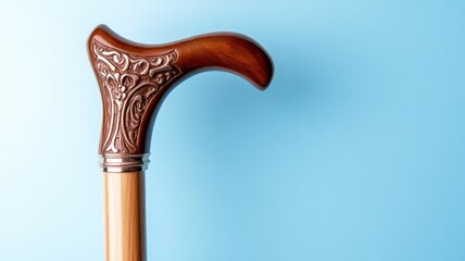 Decorative wooden cane with patterned handle on blue background