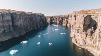 Majestic cliffs frame tranquil waters, dotted with drifting iceb